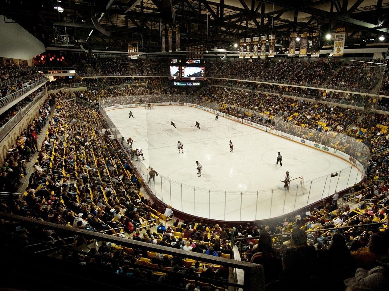 Luchtfoto van een volgepakt stadion bij een college ijshockeywedstrijd.